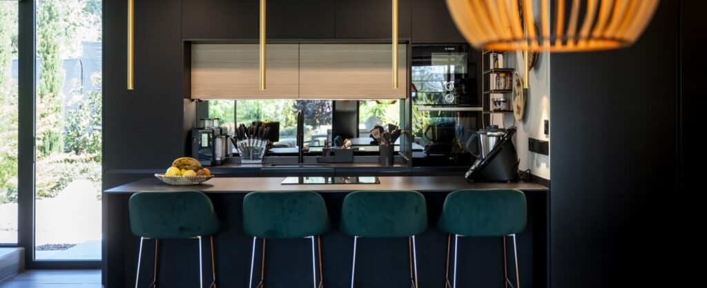 cocina con muebles negros y sillas verdes