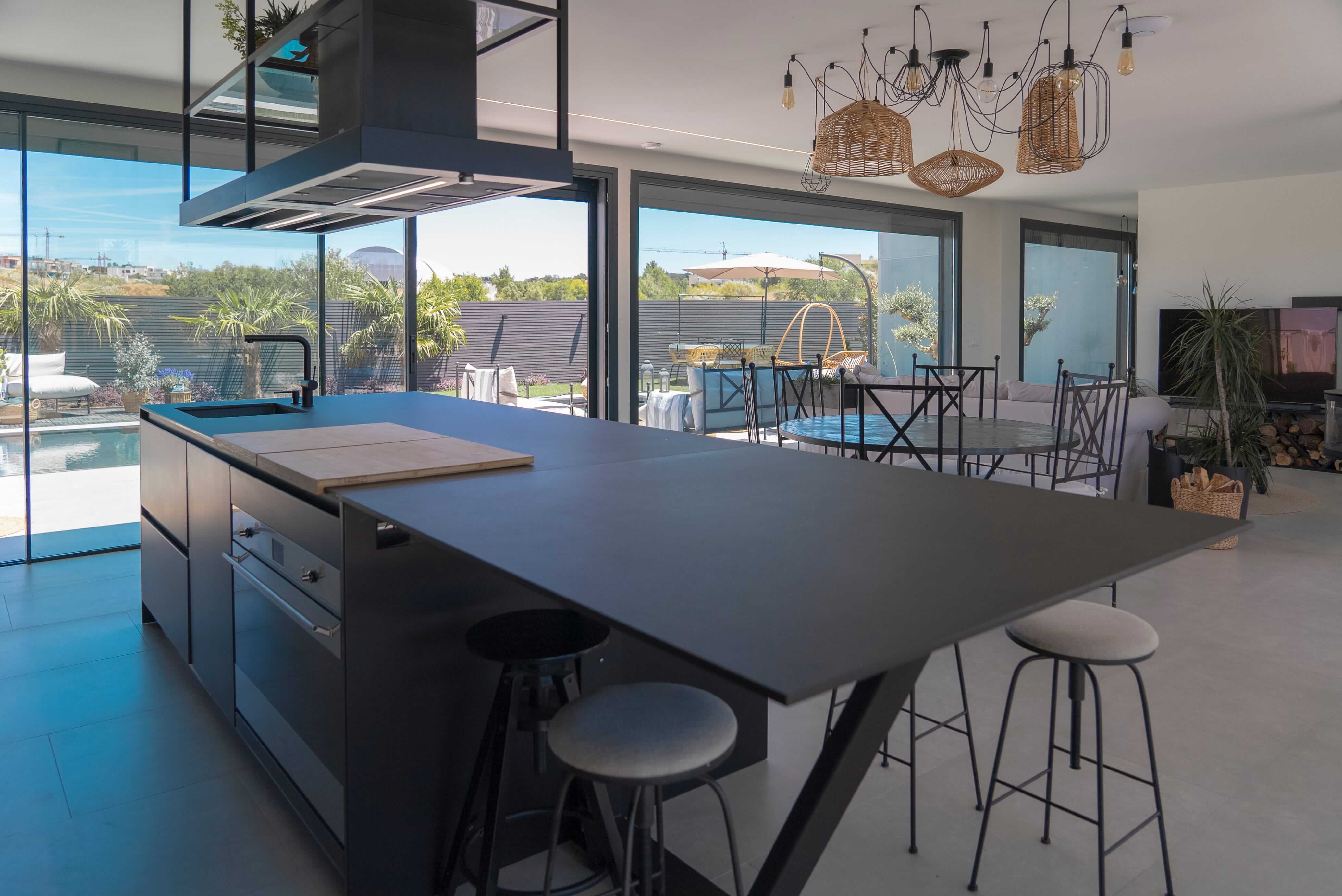 Cocina negra abierta y conectada visualmente con el salón Cocina negra abierta y conectada visualmente con el salón